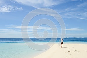 beautiful young girl walking on tropical beach photo