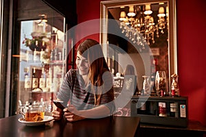 Single young lady sitting in a bar