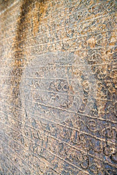 Sinhala inscription on the flat stone surface photo