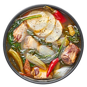 Sinigang na Baboy dish or Filipino Pork Meat Soup in black bowl isolated on white backdrop. Filipino Food. Asian Meal photo