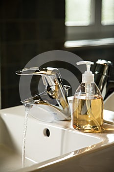 Sink with runnig water and liquid soap dispenser photo