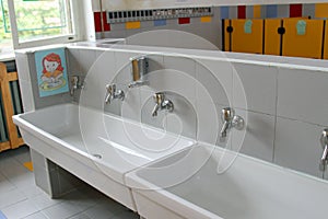 Sinks and washbasins with low taps in the toilets of a nursery