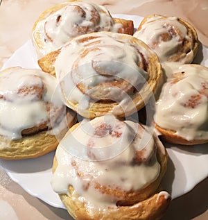 Sinnabon buns. Cinabon rolls with cream cheese on a white plate