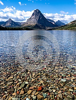 Sinopah Mountain with colorful lake stones in Two Medicine Lake photo