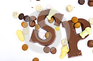 Sinterklaas chocolate letters S and P surrounded by gingerbread cookies and meringues on a white background
