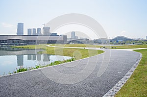 Sinuous blacktopped pedestrian way around lake in sunny summer photo