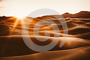 Sinuous Merzouga dunes and sunlight at sunrise, Sahara Desert, Morocco