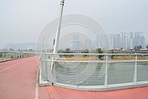 Sinuous suspended footbridge across river in light winter mist