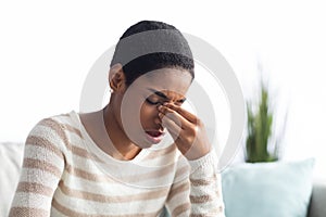 Sinusitis Concept. Sick Young Black Woman Touching Her Nose Bridge At Home