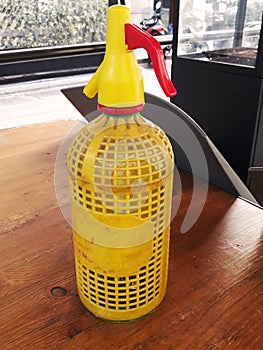 Siphon water bottle yellow over a bar table photo
