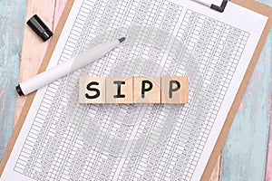 SIPP - inscription on wooden cubes on a white background along with a tabular document. finance and business concept