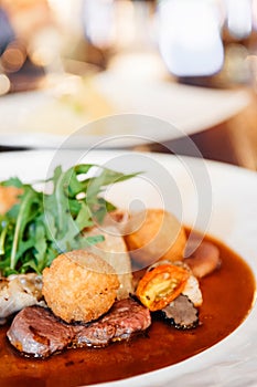 Sirloin beef steak with potato crogettes and arugula salad and g