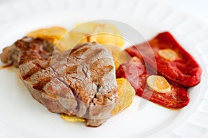 Sirloin steak with fries and red peppers photo