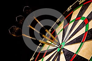 Sisal dartboard with three darts in a bullseye