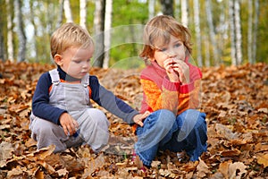 Sister with brother children in autumn park