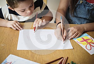 Sister and brother drawing at a table