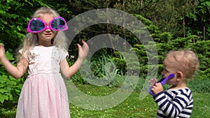 Sister and brother embrace. Two kids, boy and girl wearing huge sunglasses