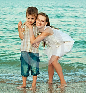 Sister and brother on the evening beach with the shells