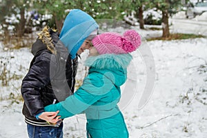 Sister and brother having fun in snowy forest