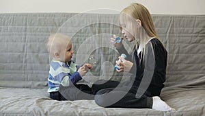 Sister and brother are having fun with soap bubbles.