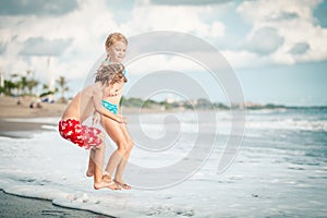 Sister and brother playing on the beach at the day time.