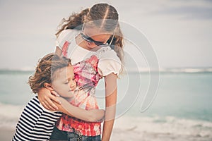 Sister and brother playing on the beach at the day time.