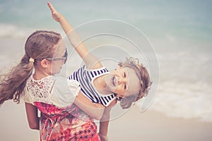 Sister and brother playing on the beach at the day time.