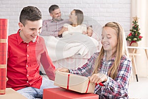 Sister and brother unwrapping gifts