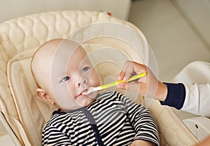 Sister feeding baby brother