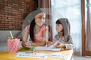 Sister help her little sibling to learn and study