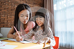 Sister help her little sibling to learn and study