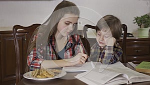 Sister helping her brother with home assignment. Portrait of two cute children working on homework together.