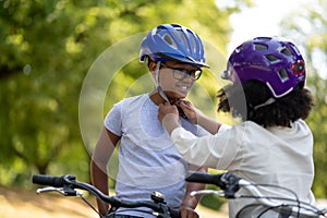Sister helping her brother to fix the protective hemlet