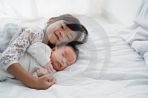 Sister with her infant newborn baby sibling play together