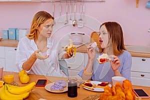 Sister leading healthy lifestyle telling teenage sibling not to eat sweets