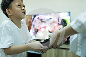 Sister, little brother fighting to get the remote control,asian sibling,aggressive kid boy and child girl fighting over the TV