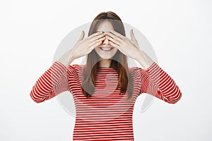 Sister playing hide and seek with teenagers, closing eyes and counting. Joyful happy young woman with brown hair