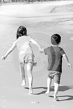 Sister pulling brother on beach