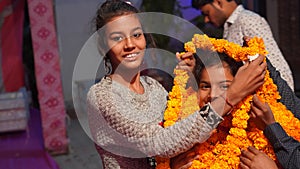 Sister welcomed her little sister with a garland. Two Indian sister having fun in evening time