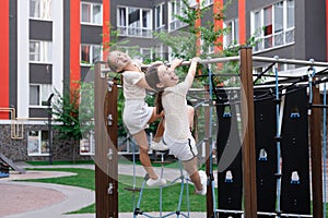 sisterhood, friendship. two charming teen girls having fun on a modern playground. sister, bffs communication photo