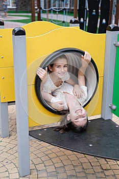 sisterhood, friendship. two charming teen girls having fun on a modern playground. sister, bffs communication