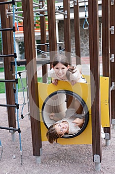 sisterhood, friendship. two charming teen girls having fun on a modern playground. sister, bffs communication photo