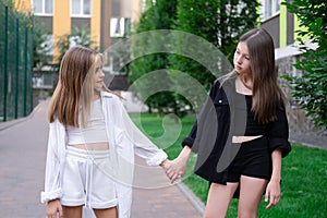 sisterhood. two sisters or friends spending time outdoors on sunny summer day. bff, sibling, girlfriend. millennial teen