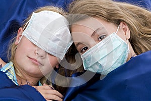 Sisters in bed with protective mask