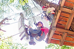 Sisters climbing in high rope course together