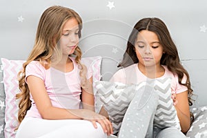 Sisters communication. Girls in cute pajamas spend time together in bedroom. Sisters communicate while relax in bedroom