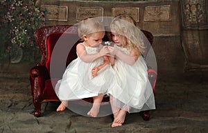 Sisters on Couch Holding Flower