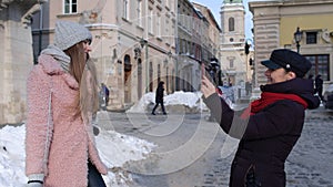 Sisters couple bloggers taking photo pictures, posing, making online video vlog on mobile phone