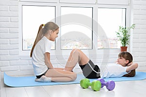 Sisters do sports exercises at home in self-isolation mode