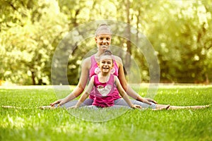 Sisters doing exercise outdoors. Healthy lifestyle